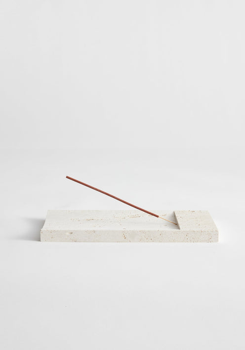 Incense holder tray | travertine, a handcrafted rectangular slab with a shallow channel, supporting a single incense stick, made by Dutch artist Louis Crombag.