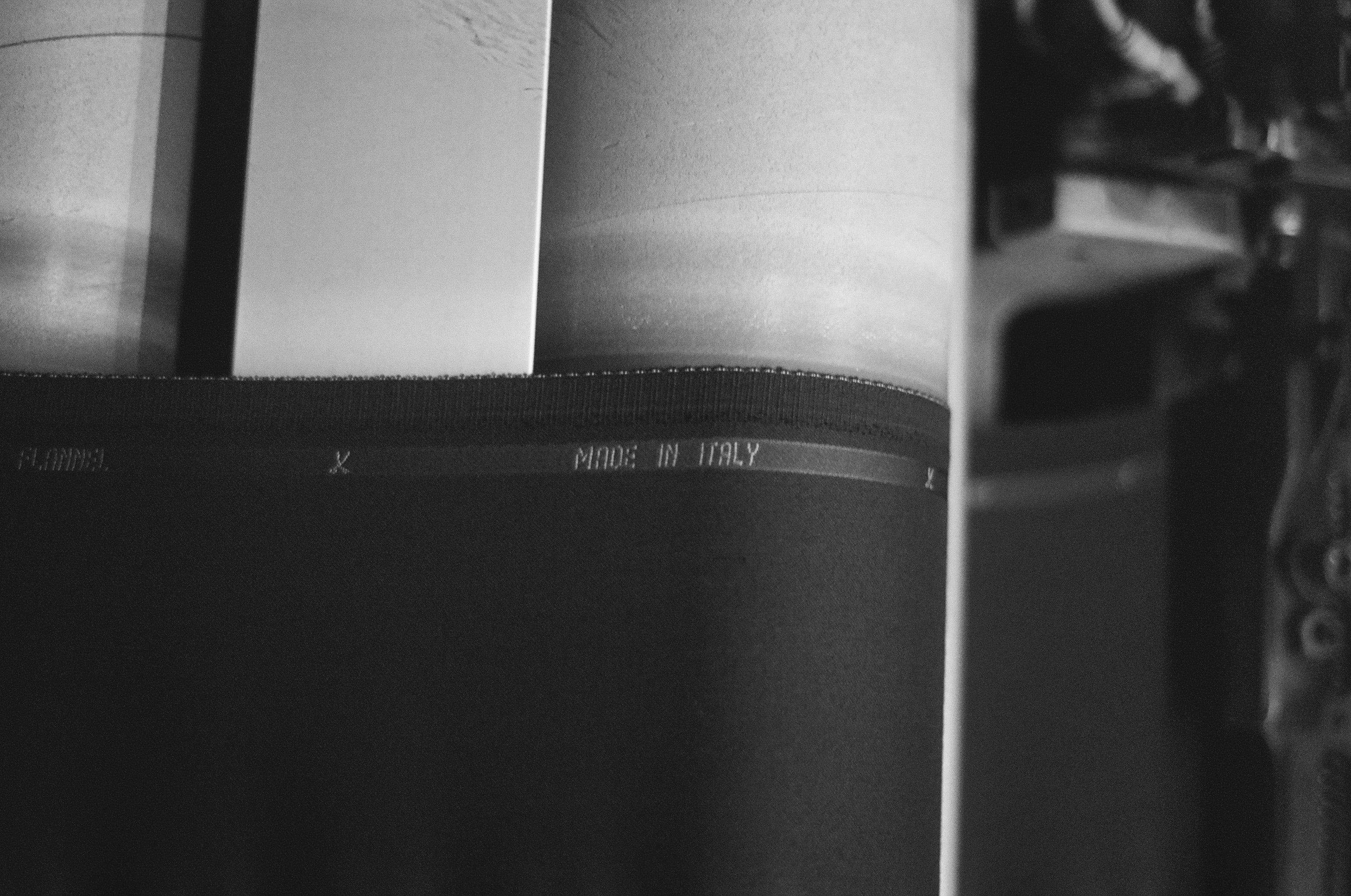 Roll of fabric with 'Made in Italy' embroidery on a machine