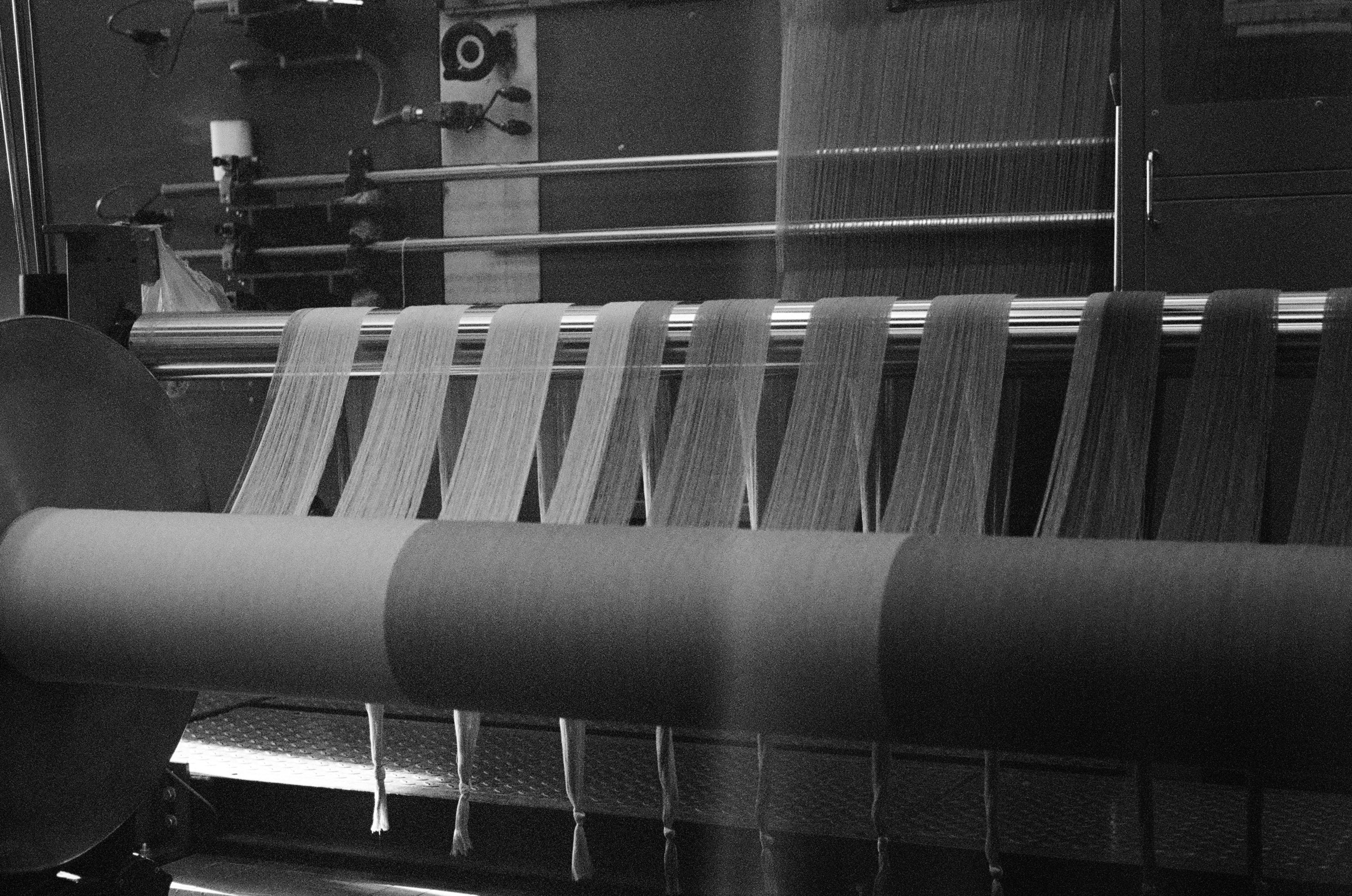 Textile production machine with yarn being woven