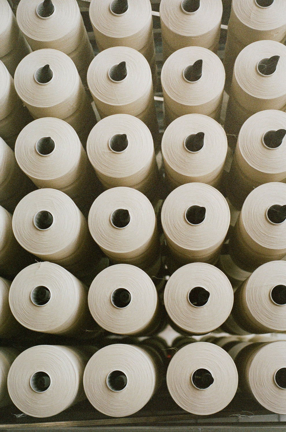 Multiple spools of thread arranged in a grid pattern.