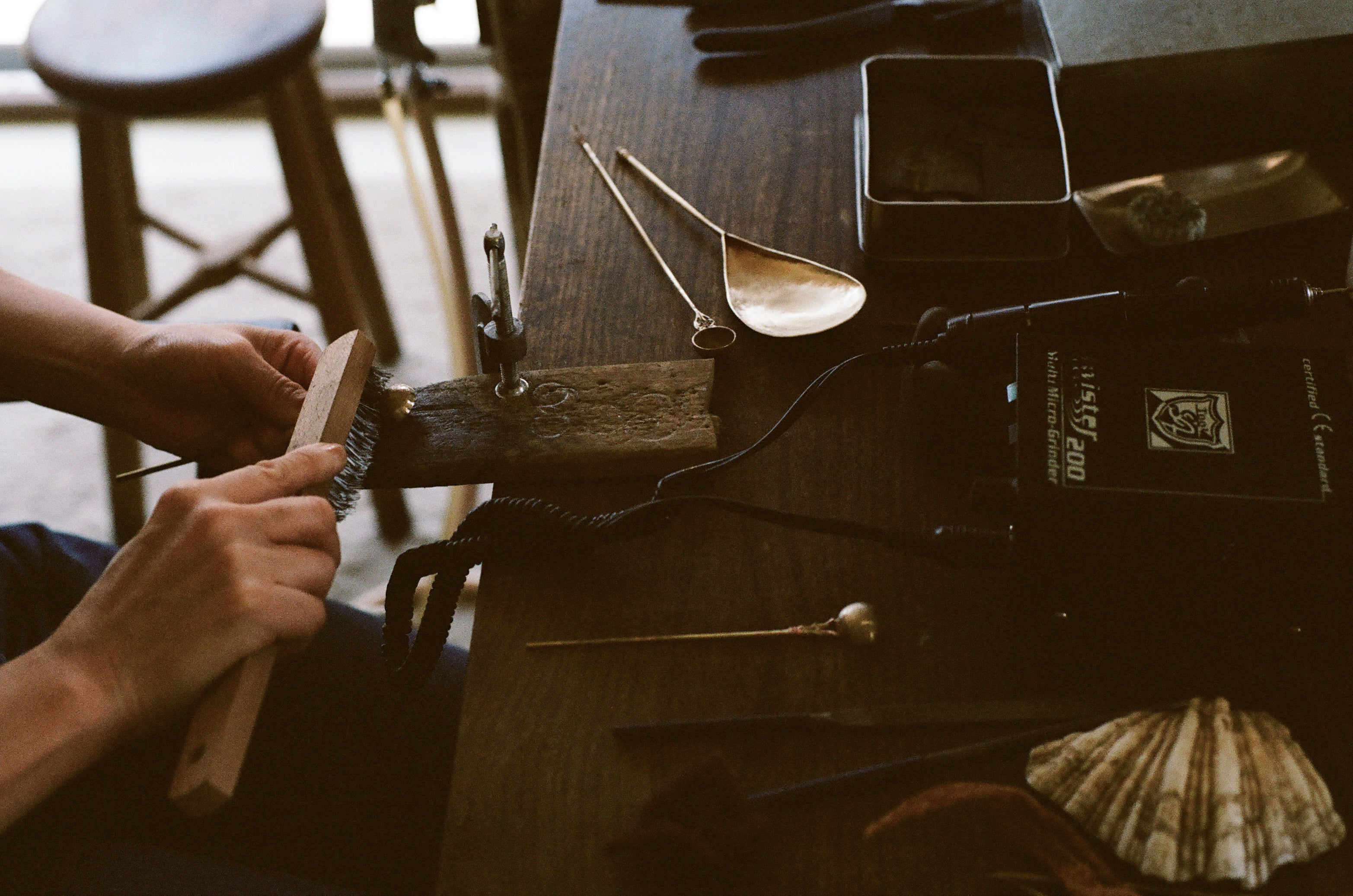 Woman working behind a table with different kinds of small tools 