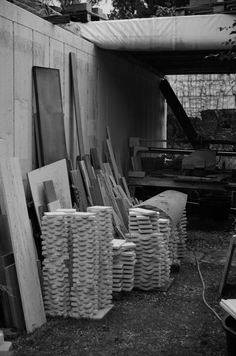 Black and white photo of a work place full of stacks of travertin stone