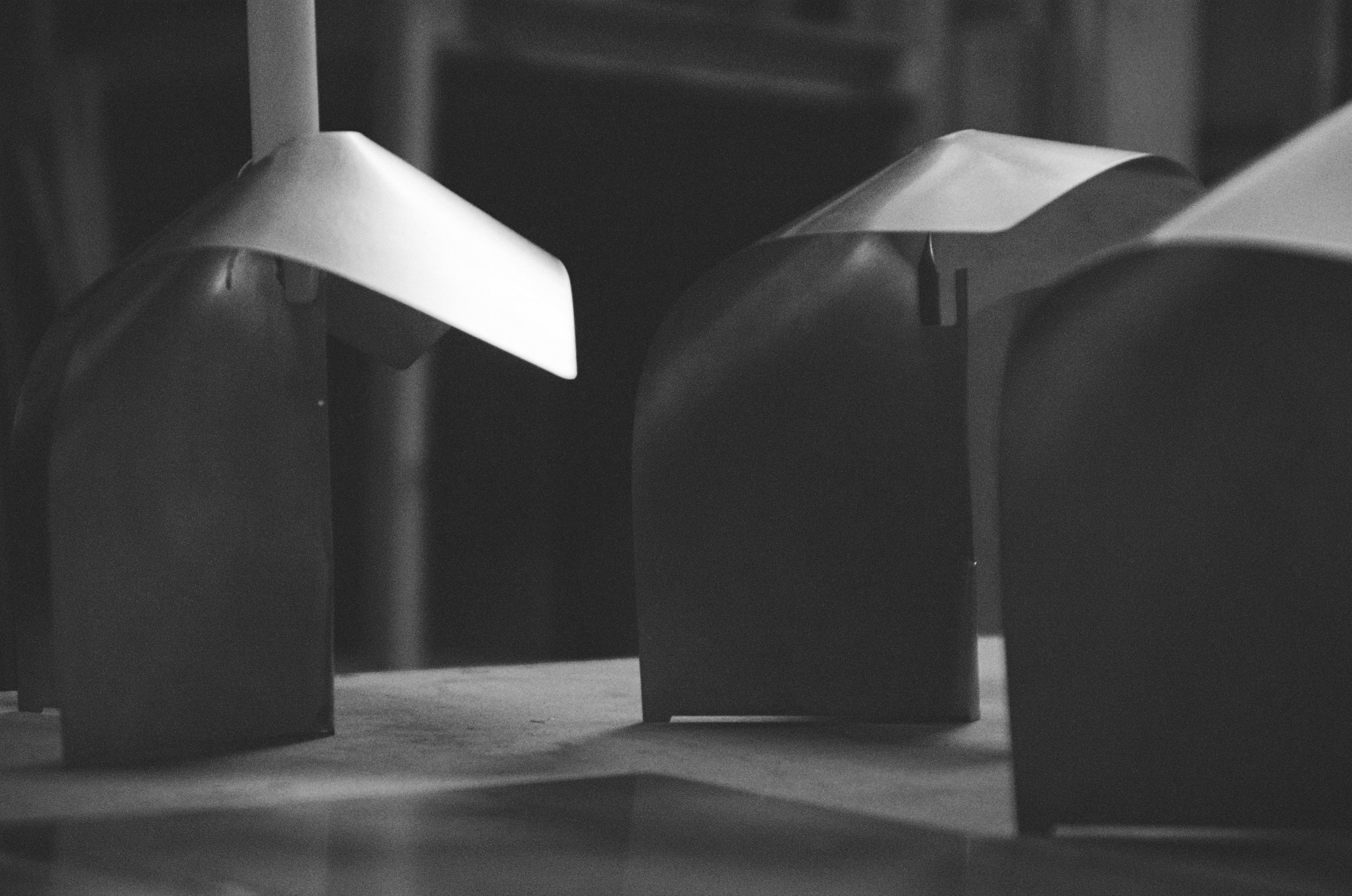 Black and white image of three sculptural stainless steel candle holders