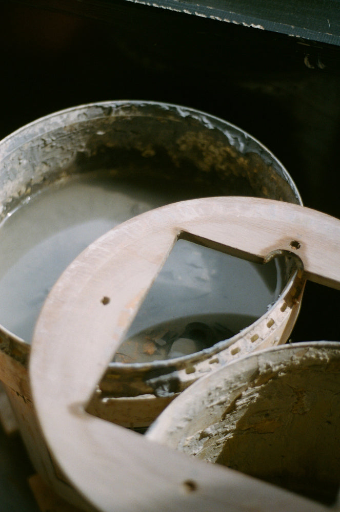 Close-up of a bucket with water and tools inside with a lid on a dark background
