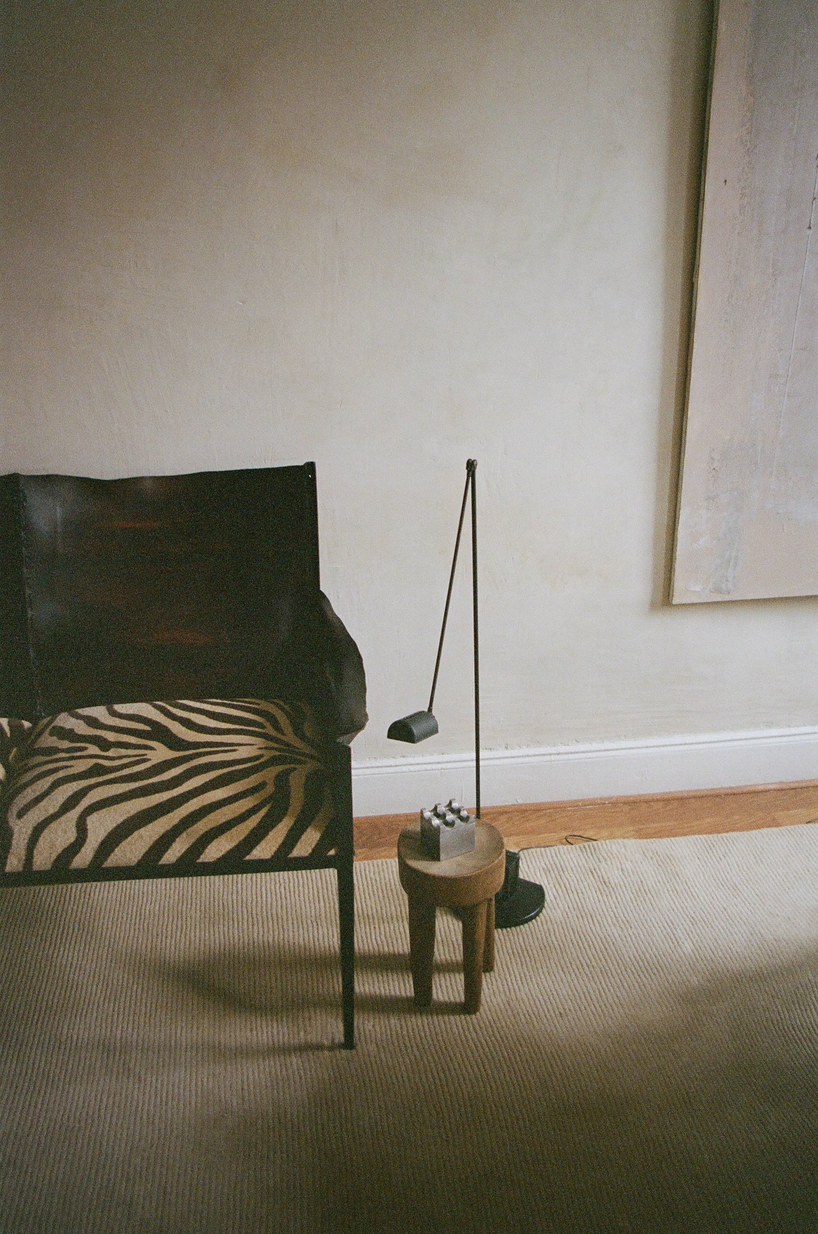 Chair with zebra-patterned cushion next to a small table in a room with neutral walls and carpet.