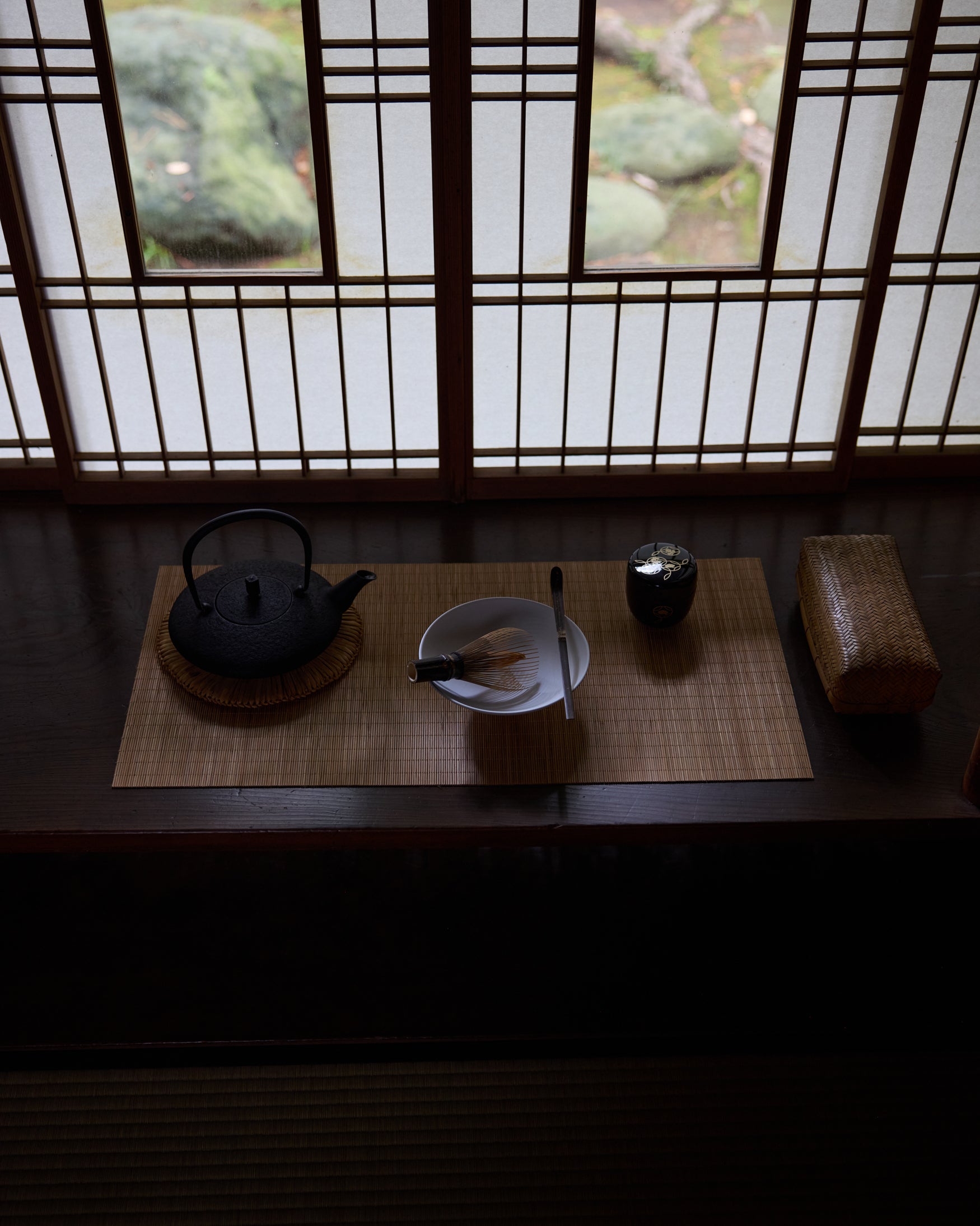 Close-up of a Japanese tea pot, matcha whisk, bowl, and japenese container. 