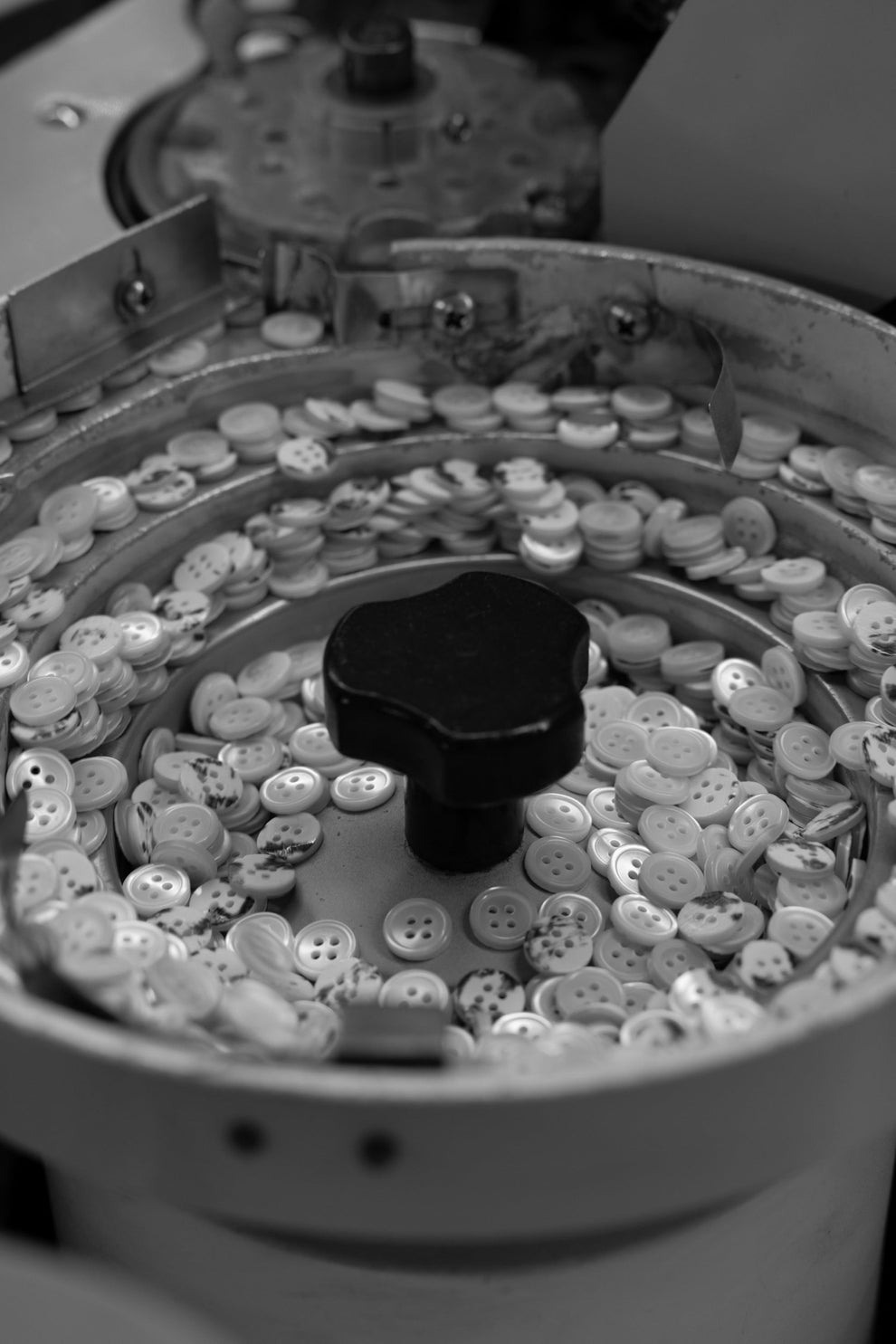 Close-up of a button machine with buttons and a black component.
