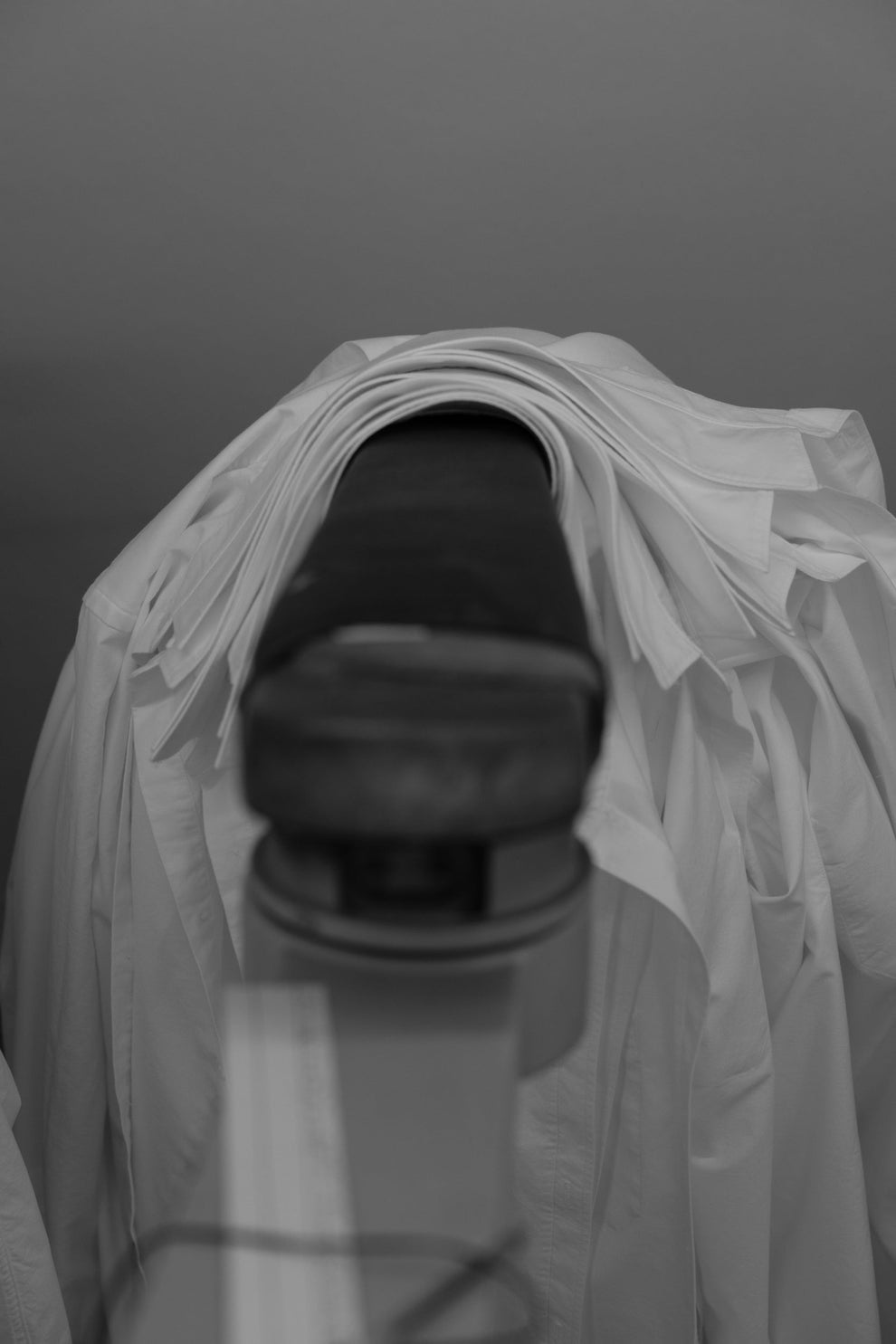 White collared shirts stacked on an ironing board showing all the stacked collars neatly