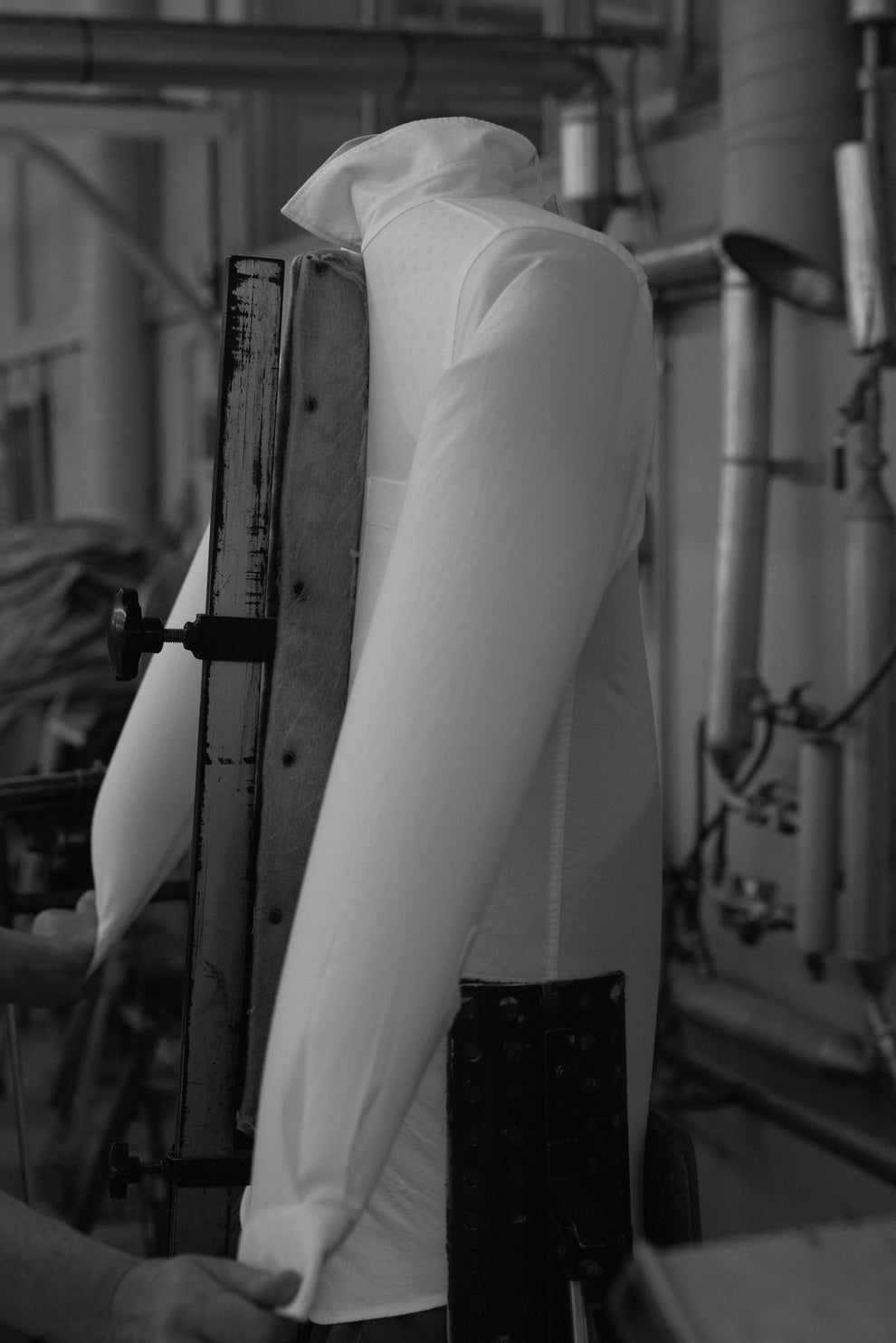 Hands holding a white shirt filled with air up straight on a steaming device