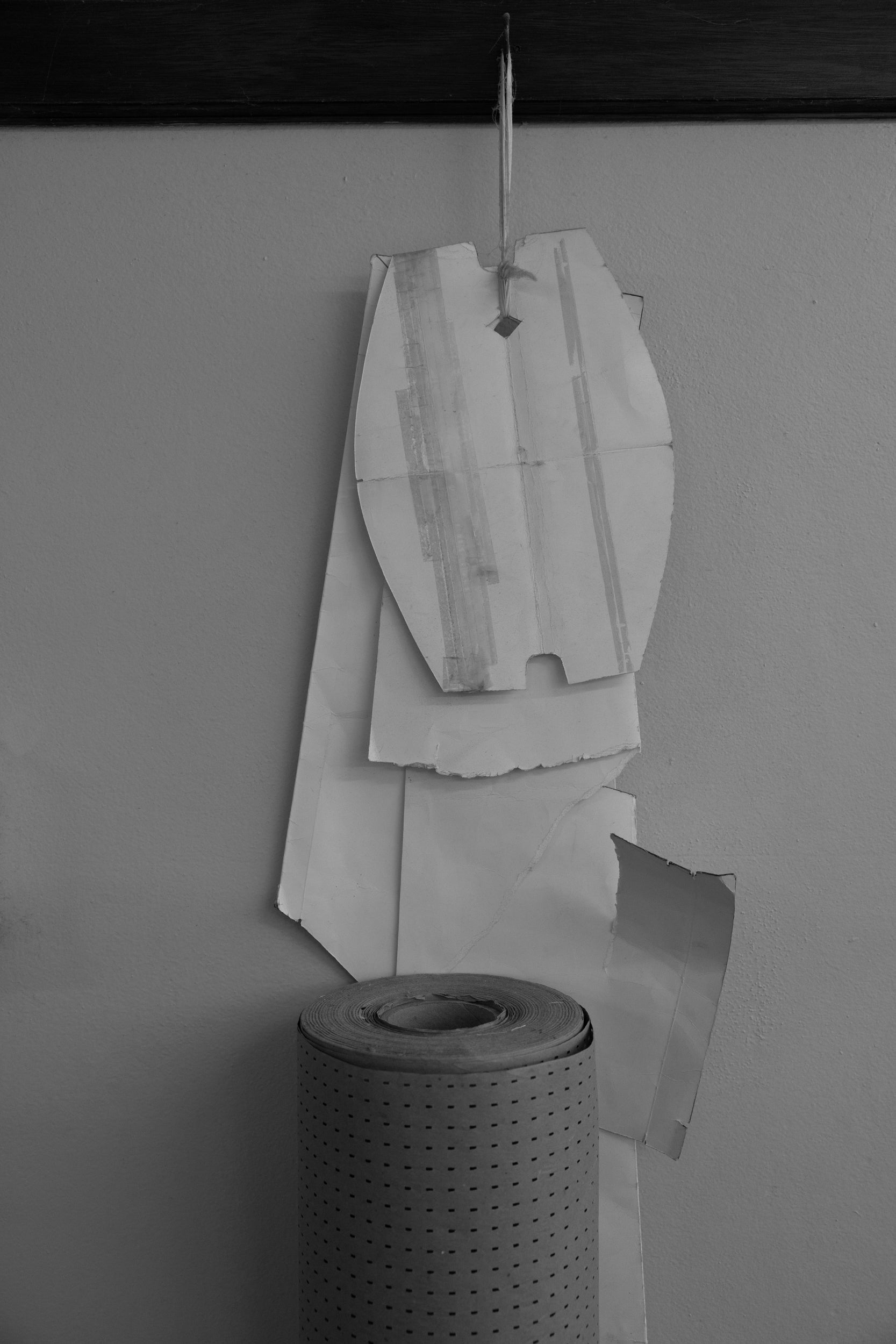 Cut-out paper pattern pieces hanging against a plain wall