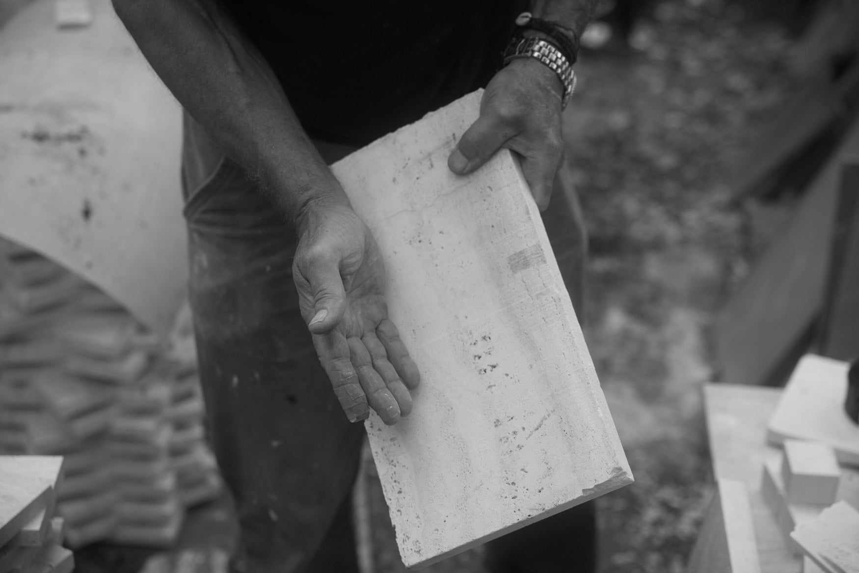 Person holding a slab of travertin against a blurred background