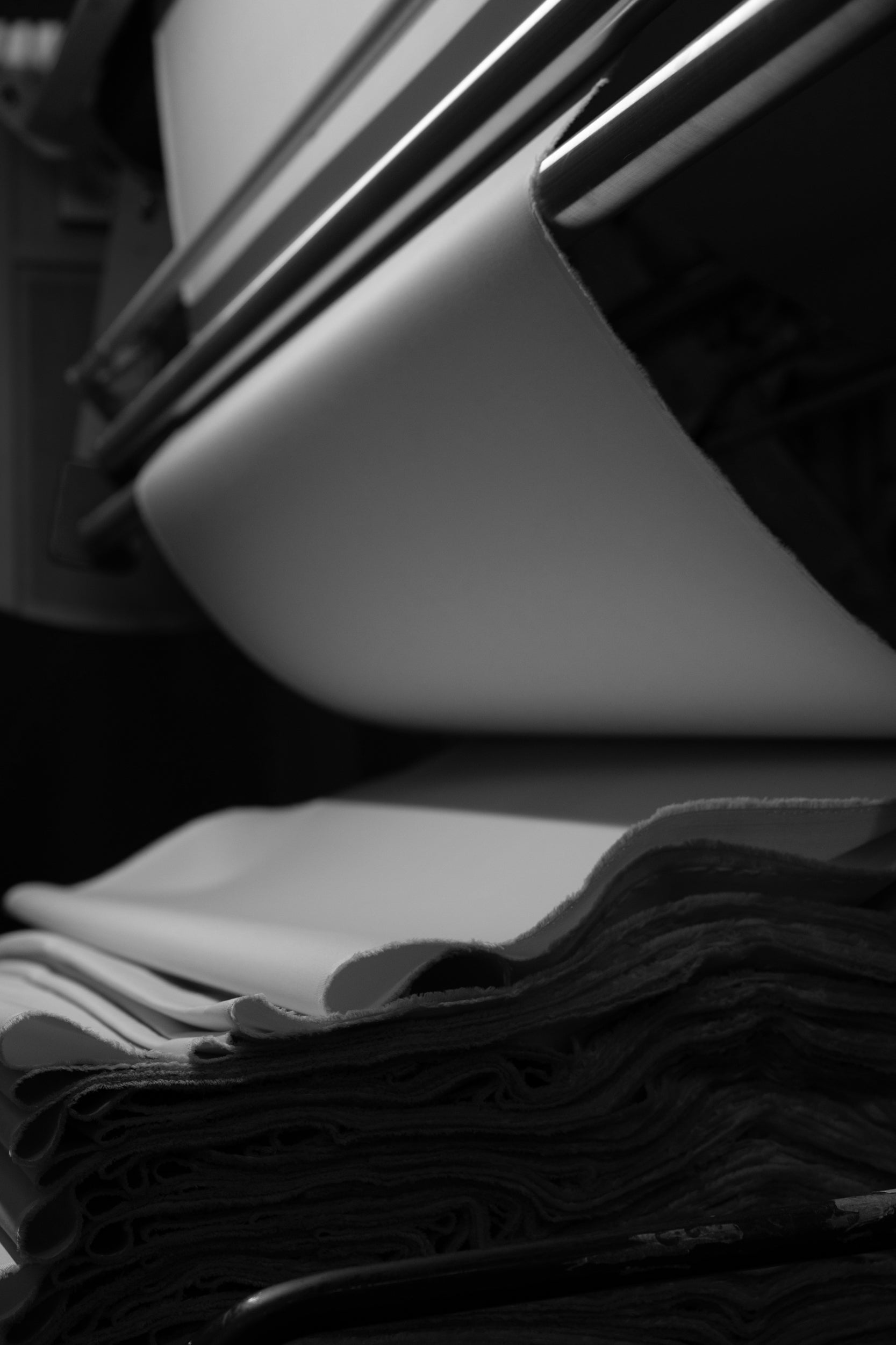 Close-up of a stack of folded fabric going through a machine with a blurred background