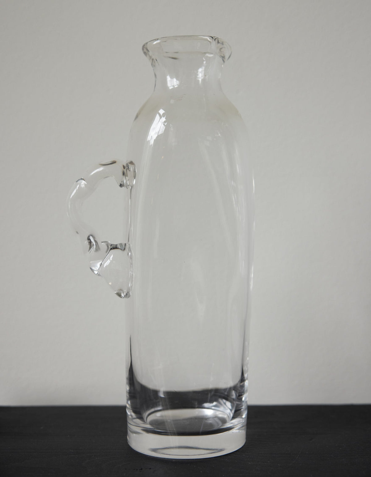 Large water carafe | Glass: A tall, hand-blown clear glass carafe with a stylized handle, showcasing unique craftsmanship by Szkło Studio.