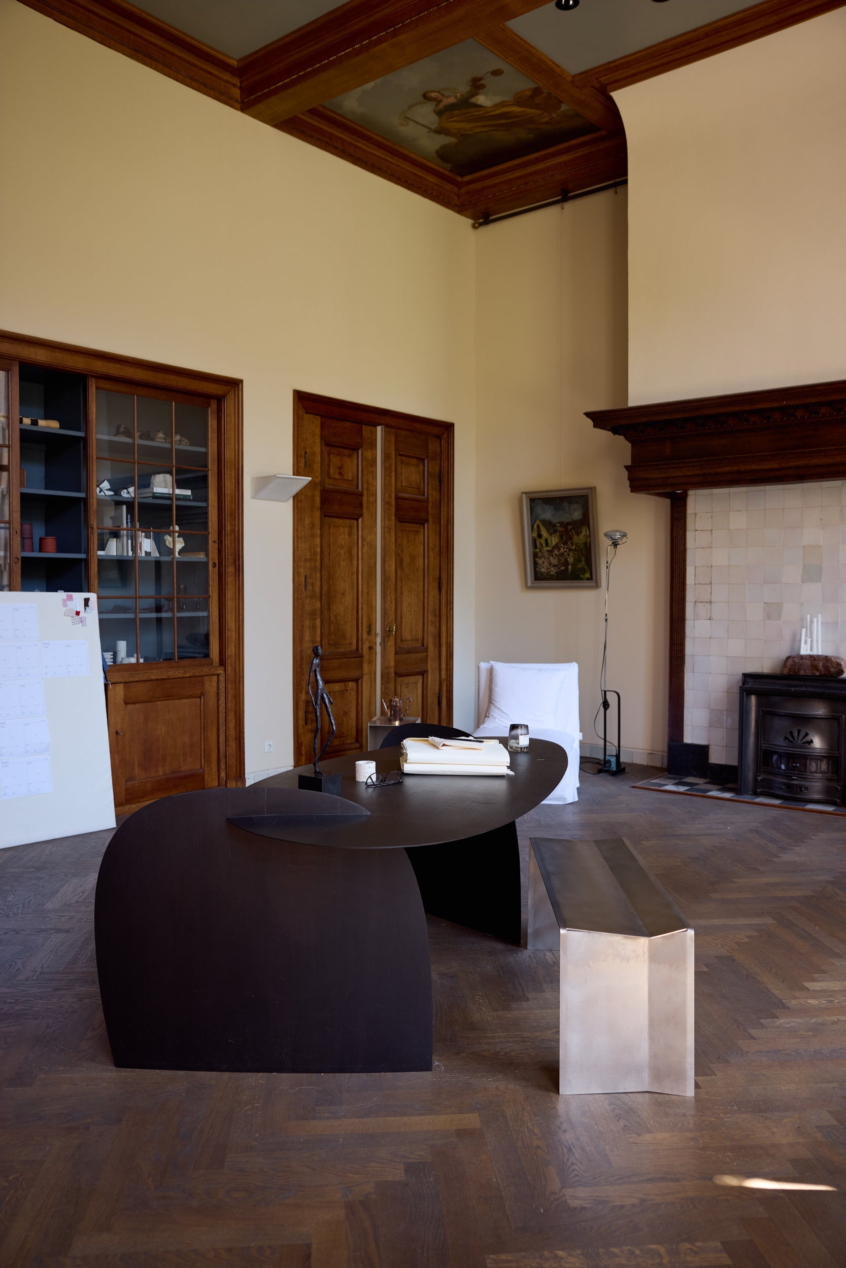 17th century interior with a large black table in the middle, wooden floor, decorative elements and ceiling paintings 