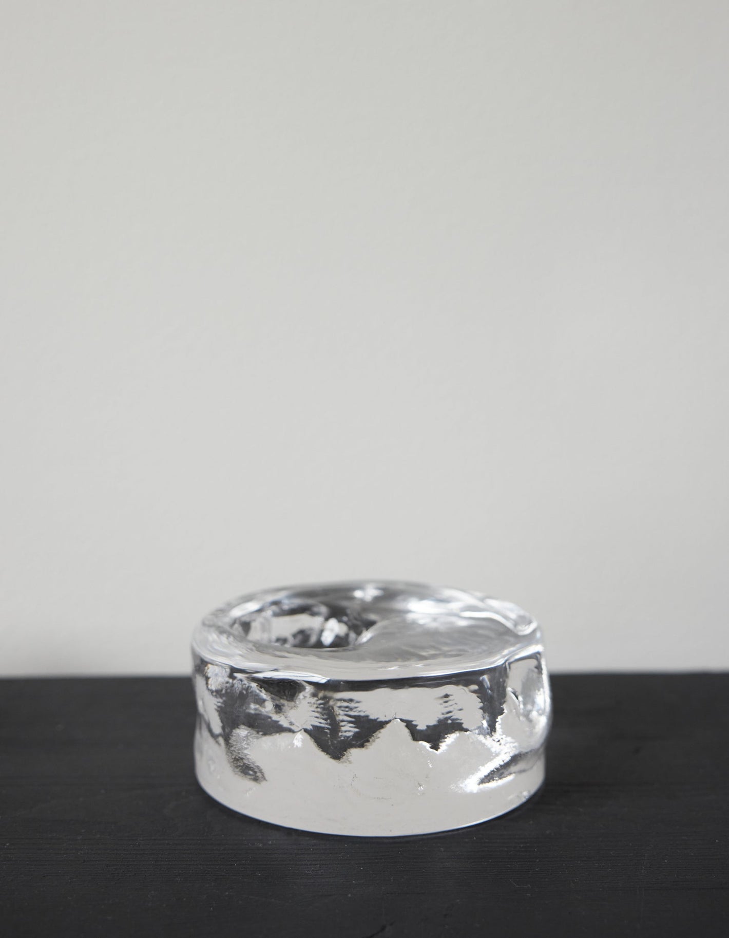 Presse-papier & holder: A thick, clear glass cylinder with undulating sides and a shallow top indentation, showcasing Szkło Studio's unique, hand-blown craftsmanship.