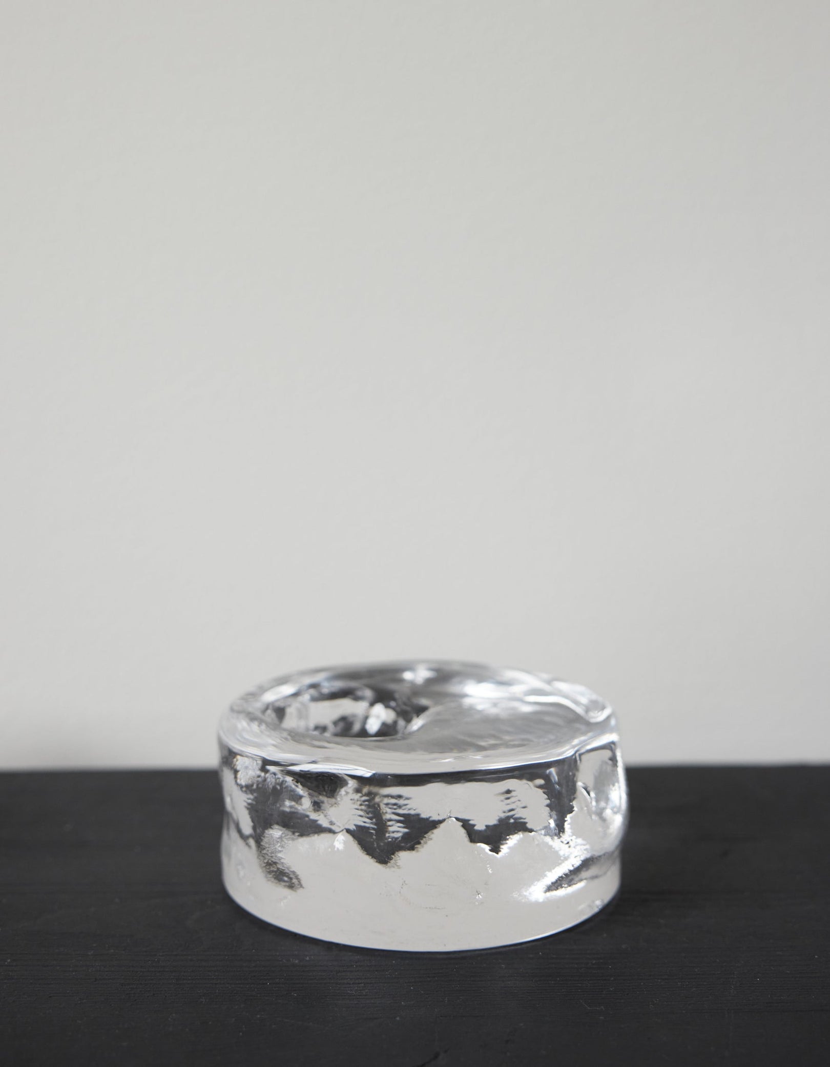 Presse-papier & holder: A thick, clear glass cylinder with undulating sides and a shallow top indentation, showcasing Szkło Studio's unique, hand-blown craftsmanship.