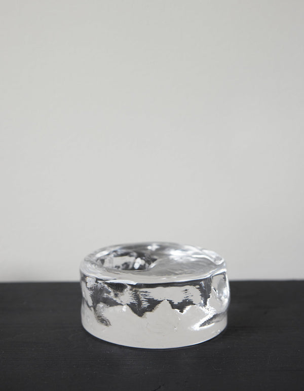Presse-papier & holder: A thick, clear glass cylinder with undulating sides and a shallow top indentation, showcasing Szkło Studio's unique, hand-blown craftsmanship.