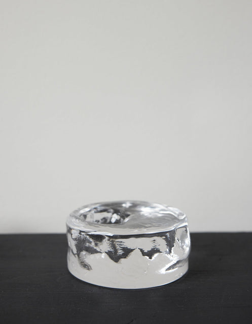 Presse-papier & holder | Glass: A single white egg stands on a transparent glass block, showcasing Szkło Studio's unique hand-blown craftsmanship and experimental design.