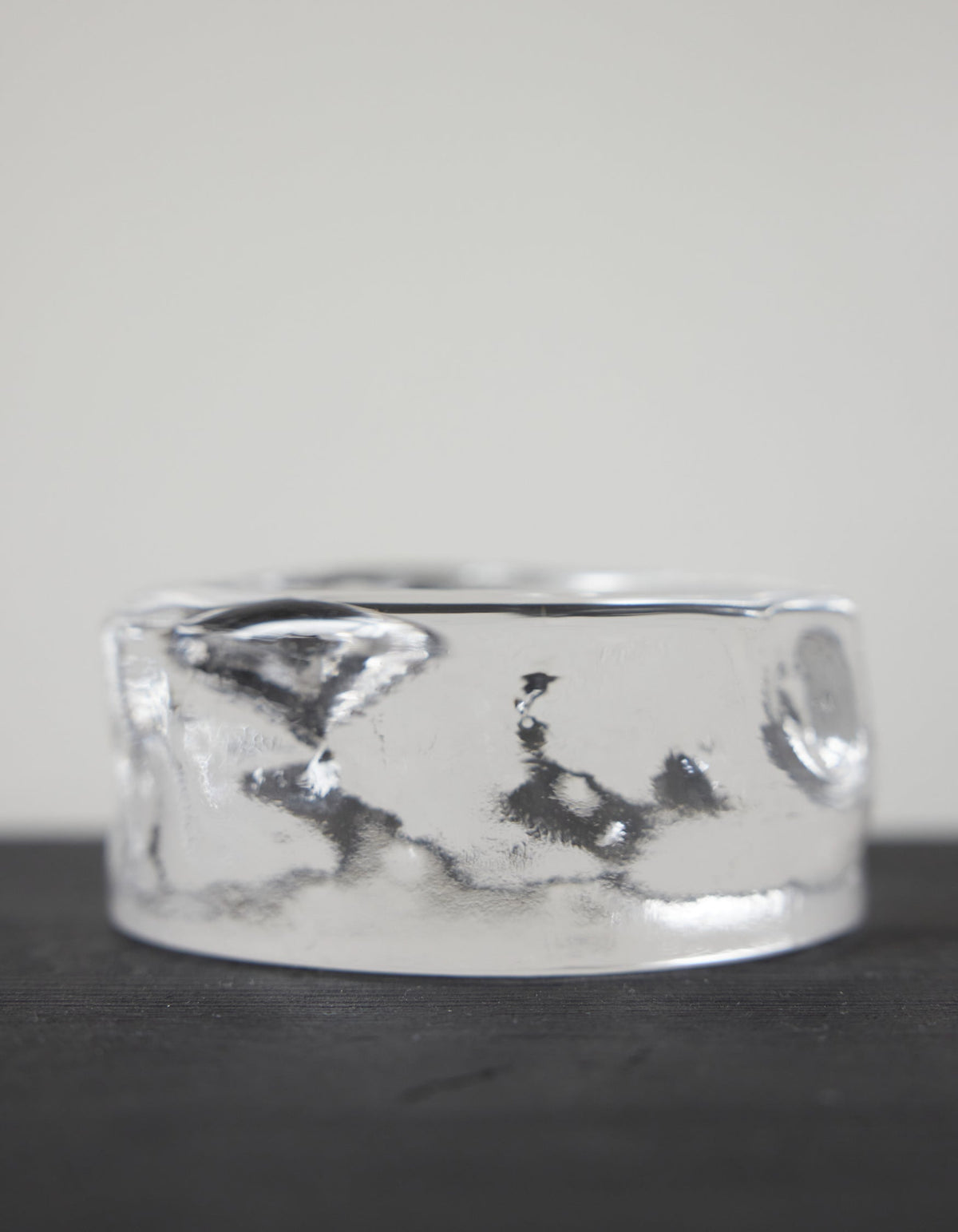 Presse-papier & holder | Glass: A smooth, clear glass-like cylinder with rippled sides, creating a wavy, liquid appearance, showcasing Szkło Studio's craftsmanship and unique design.