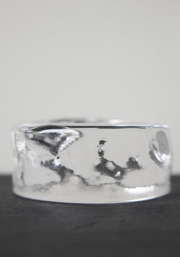 Presse-papier & holder | Glass: A smooth, clear glass-like cylinder with rippled sides, creating a wavy, liquid appearance, showcasing Szkło Studio's craftsmanship and unique design.