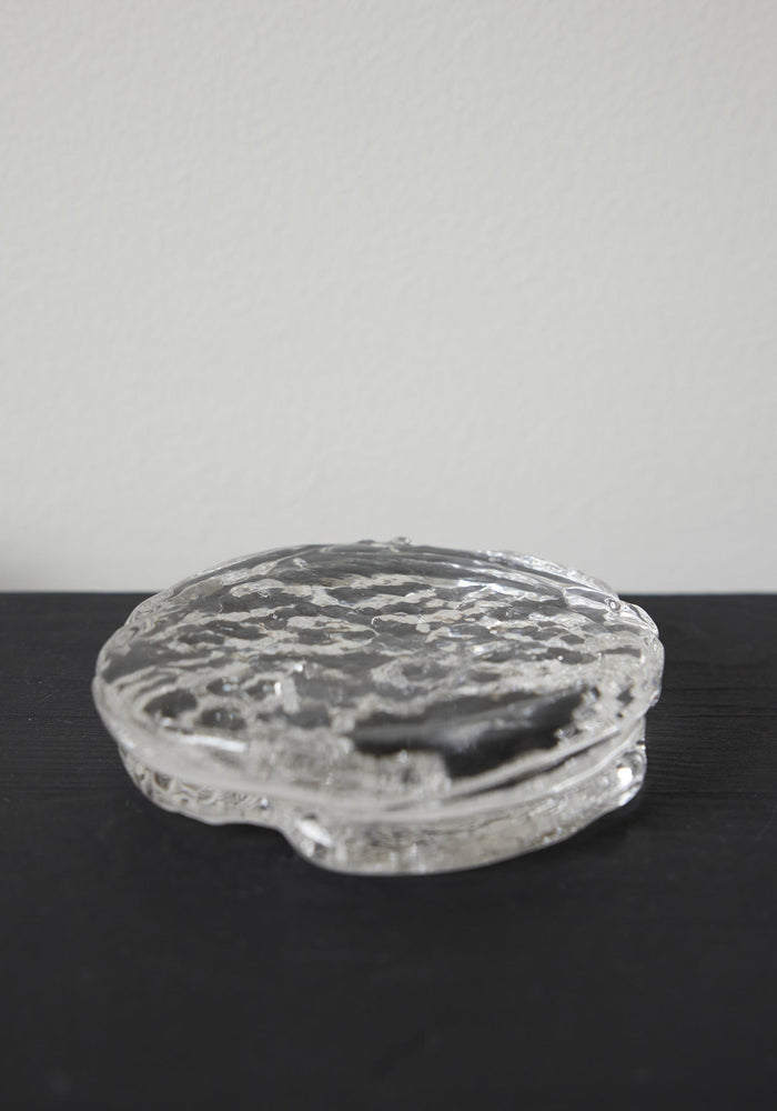 Butter plate | Glass: A small, round, clear-glass container with an ice-textured surface, showcasing Szkło Studio's unique, hand-blown craftsmanship and experimental design approach.