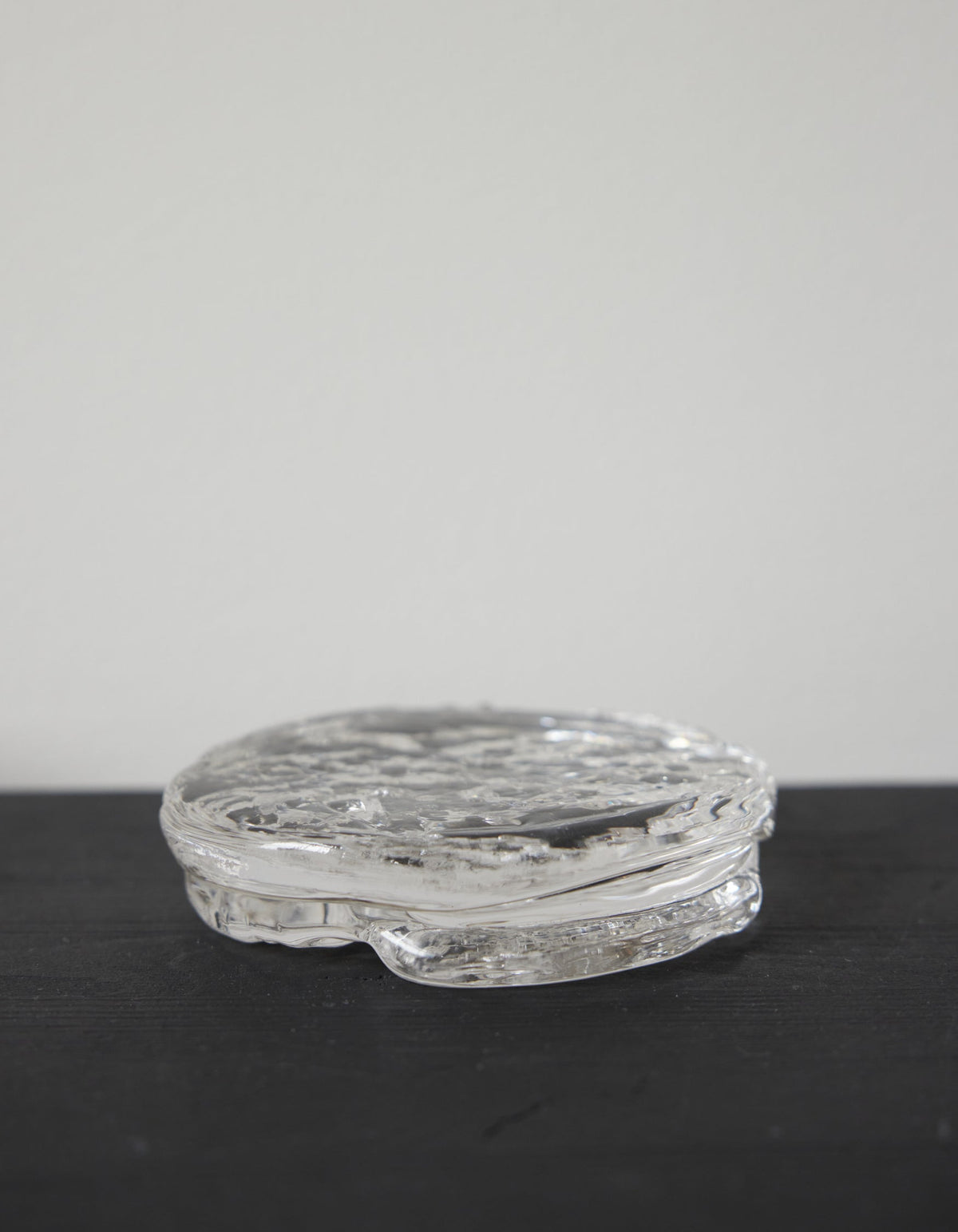 Butter plate | Glass: A clear, disc-shaped glass object with a rippled texture, crafted by Szkło Studio, showcasing unique hand-blown design and functional artistry.