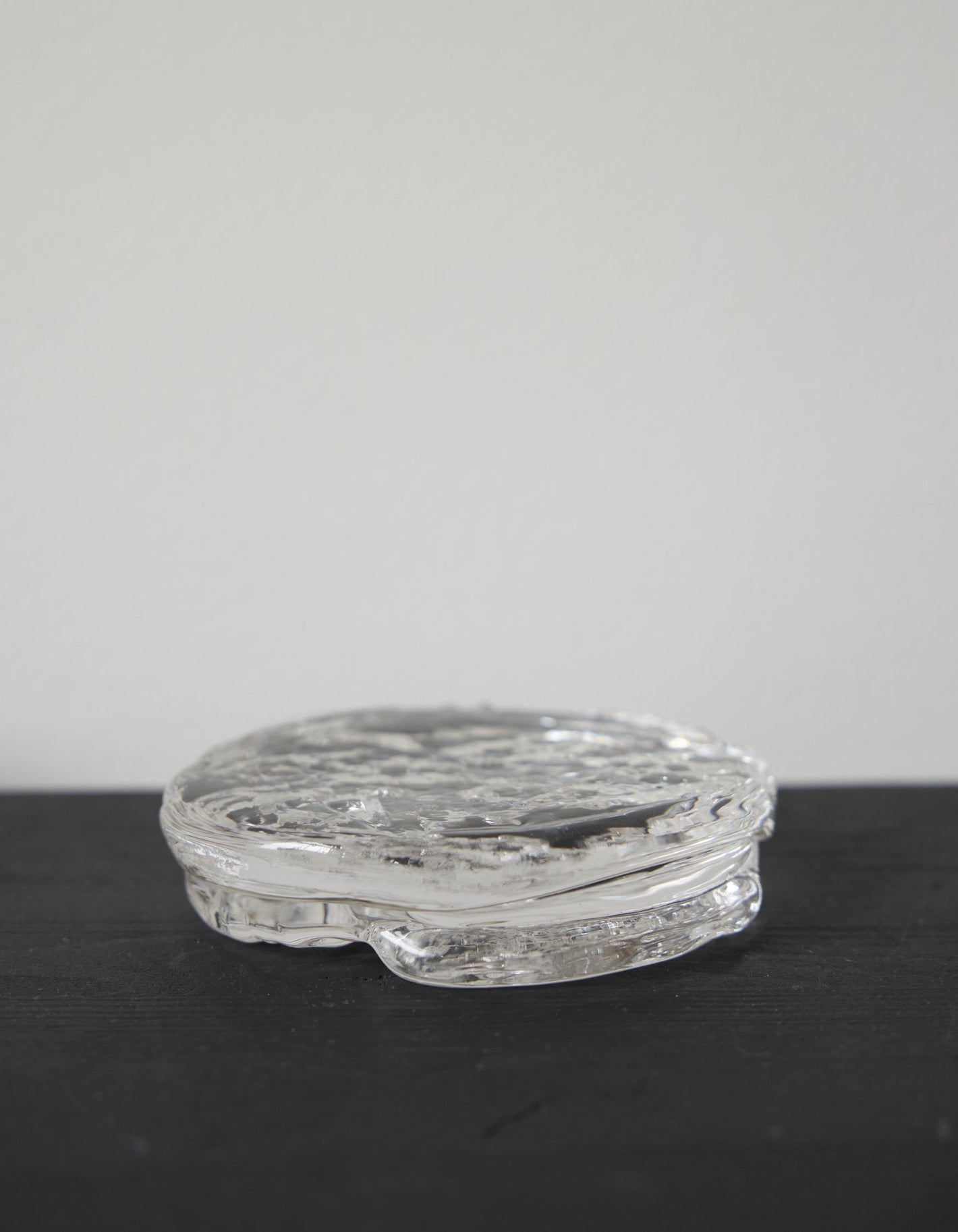Butter plate | Glass: A clear, disc-shaped glass object with a rippled texture, crafted by Szkło Studio, showcasing unique hand-blown design and functional artistry.