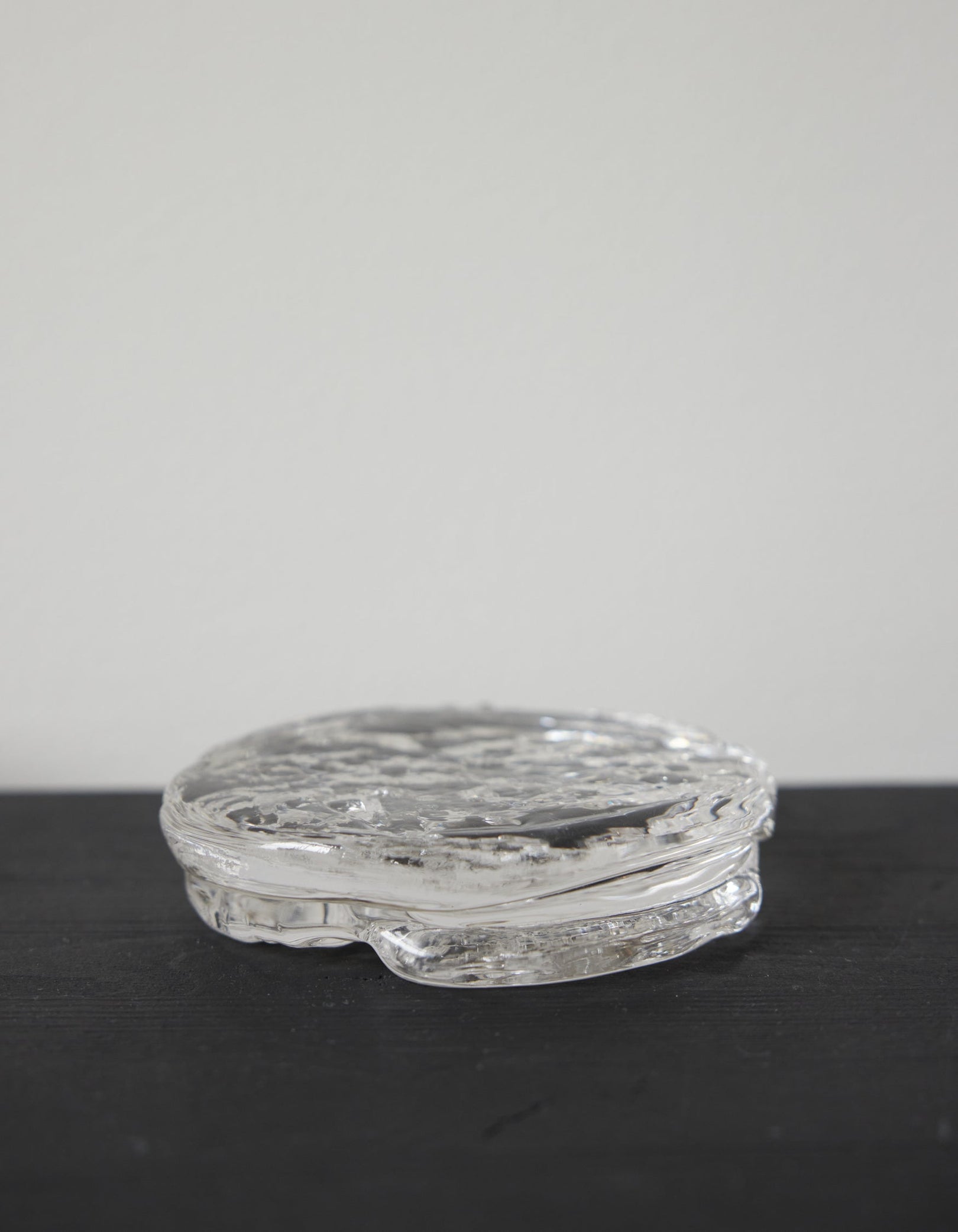 Butter plate | Glass: A clear, disc-shaped glass object with a rippled texture, crafted by Szkło Studio, showcasing unique hand-blown design and functional artistry.