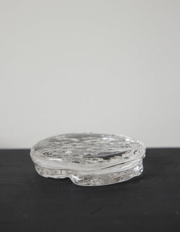Butter plate | Glass: A clear, disc-shaped glass object with a rippled texture, crafted by Szkło Studio, showcasing unique hand-blown design and functional artistry.
