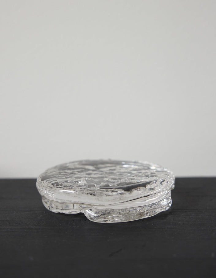 Butter plate | Glass: A small, round, clear-glass container with an ice-textured surface, showcasing Szkło Studio's unique, hand-blown craftsmanship and experimental design approach.