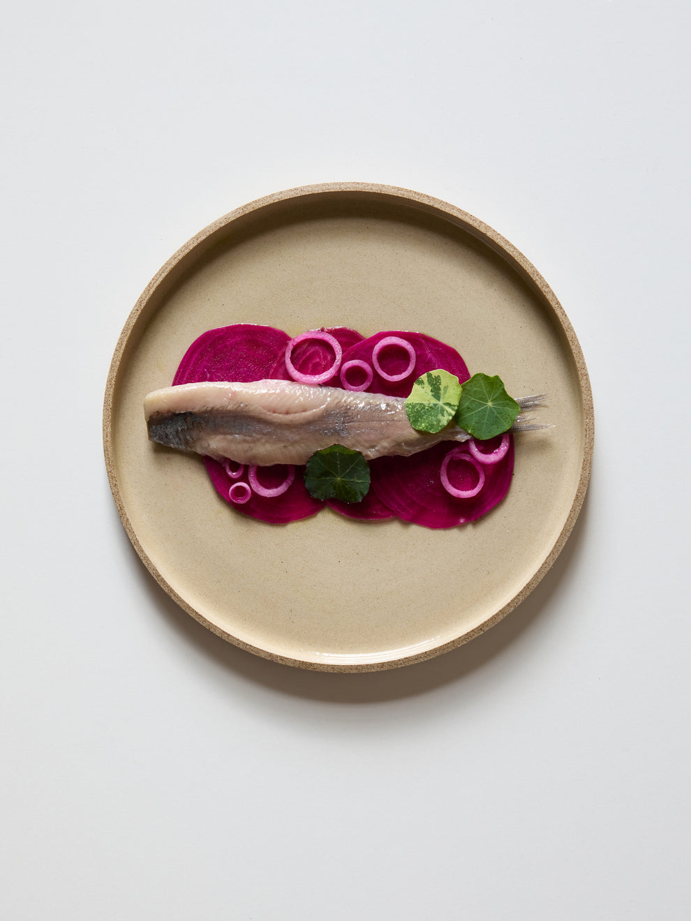 Plate with a composition of beets, herring and pickled onion