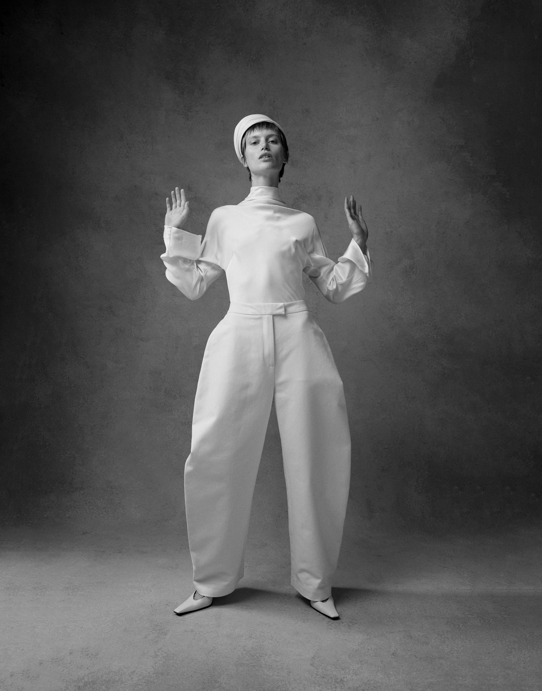 Woman wearing a cream outfit with cream barrel leg trousers 