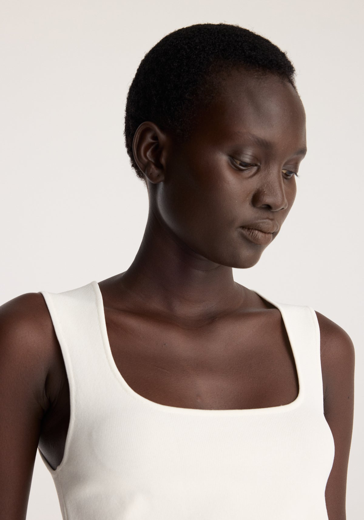 Bustier shaped knitted top | optic white worn by a model in close up with a square neckline and wide shoulder straps