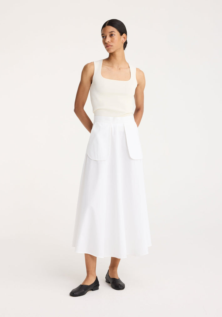 Model wearing Bustier shaped knitted top in off-white, featuring a sleeveless design and square neckline, paired with a high-waisted A-line midi skirt.
