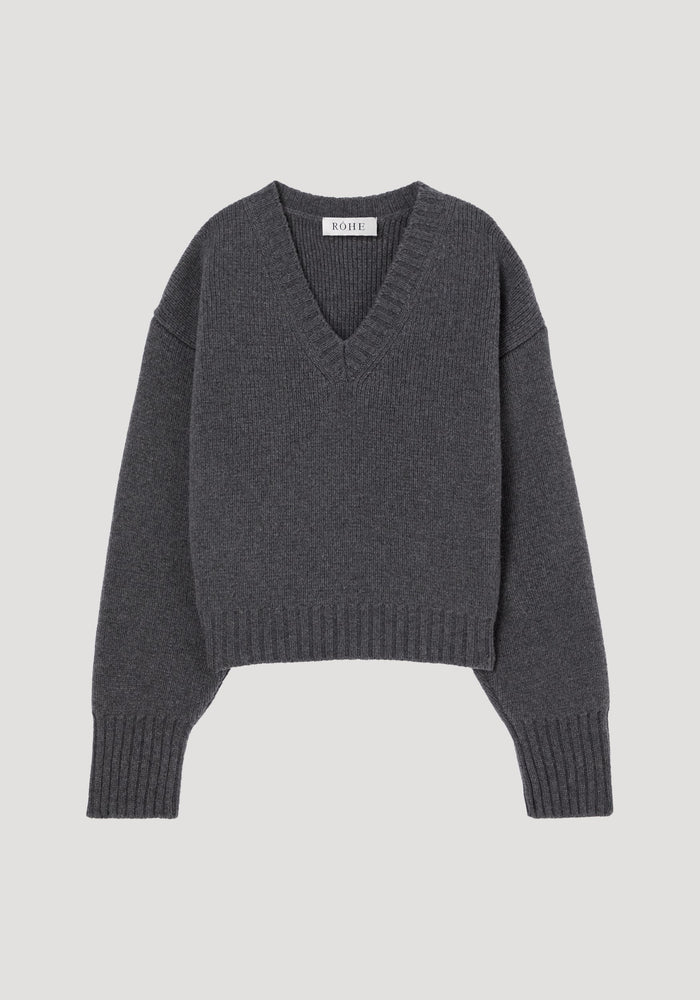 Sculptural compact v-neck in mid grey melange, featuring a charcoal-grey, V-neck knitted design with ribbed cuffs and hem, crafted from 100% wool by RÓHE.