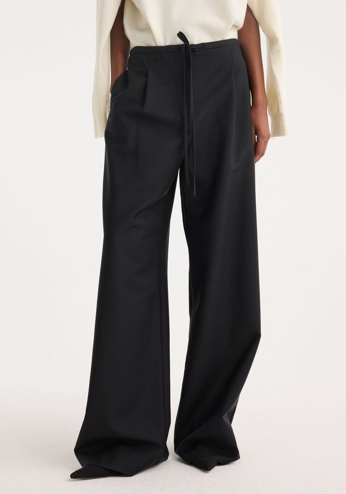 Relaxed drawstring trousers in black, featuring a high-waisted, wide-leg design with front pleats and side pockets, crafted from a soft wool-mohair blend.