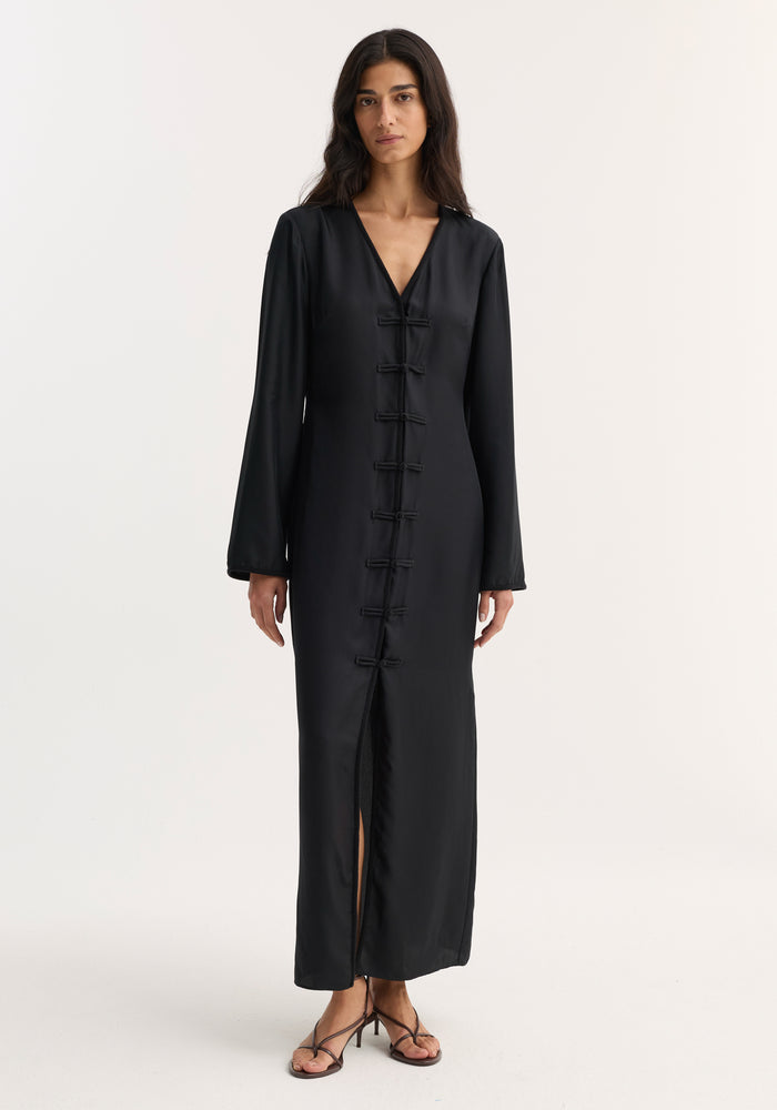 Mandarin silk dress | black: Model in a long, black silk dress with V-neck, pankou closures, long sleeves, and front slit, showcasing elegance and luxurious craftsmanship.