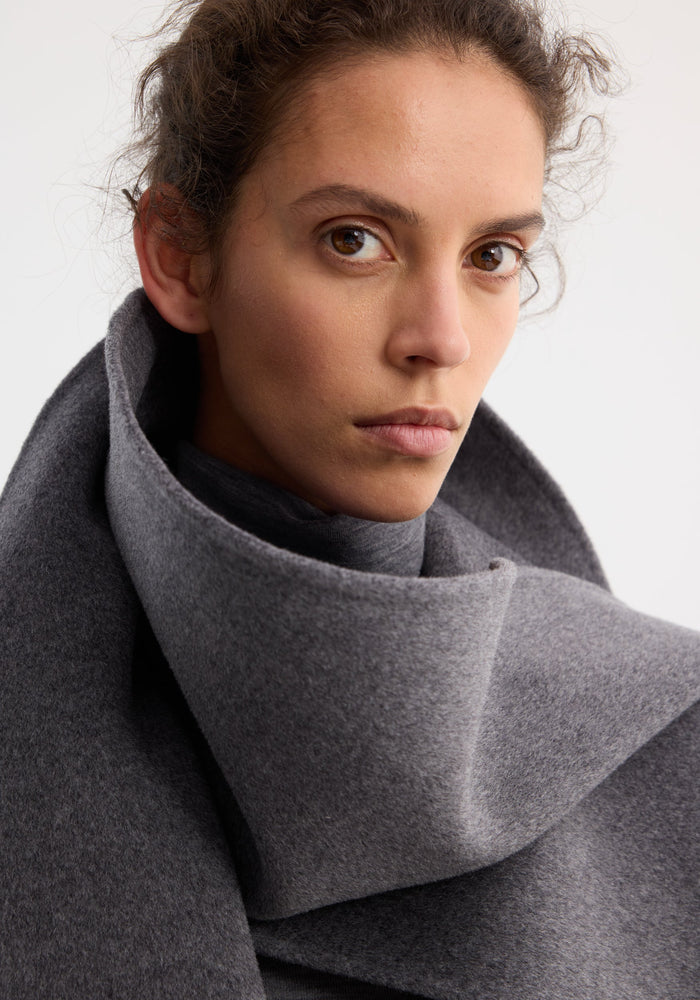 Young woman wearing the Signature double-faced scarf coat in mid grey melange, featuring an oversized, double-layered scarf collar, crafted from a wool-cashmere blend.