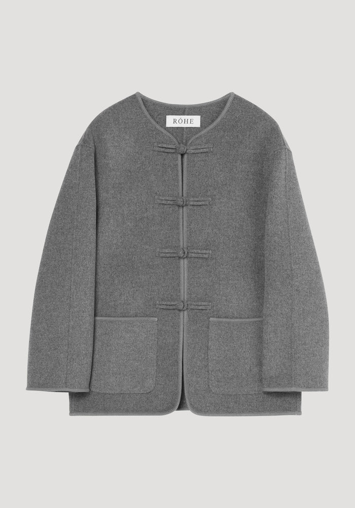 Mandarin double-faced wool jacket in mid grey melange with four frog closures, embroidered edges, patch pockets, and a simple rounded neckline, labeled RÓHE.