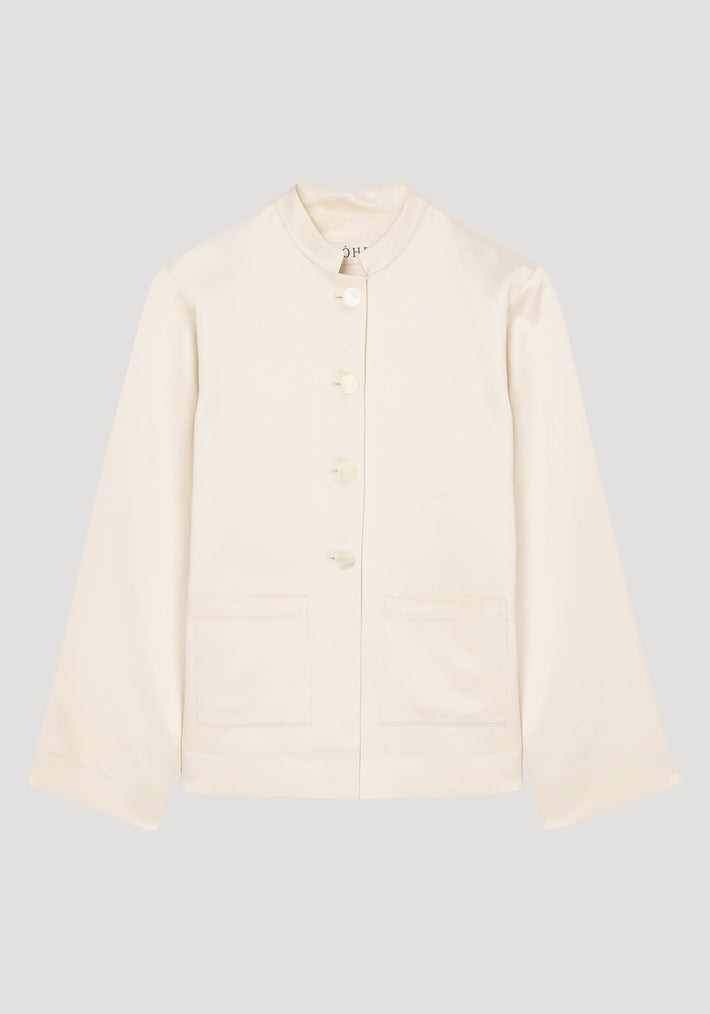 Mandarin pearl button satin jacket in cream with long sleeves, a stand-up collar, front-button closure, and two patch pockets, showcasing a minimalist and refined design.