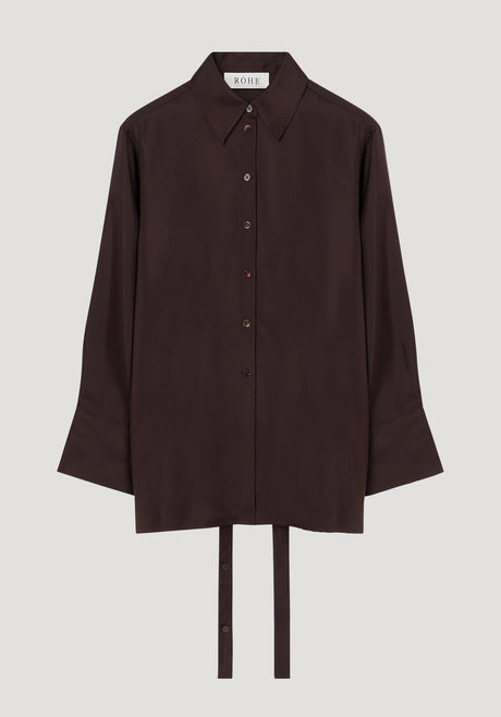 Deconstructed silk shirt in mahogany with an open back, pointed collar, and fabric ties for styling versatility, featuring a RÓHE label inside.
