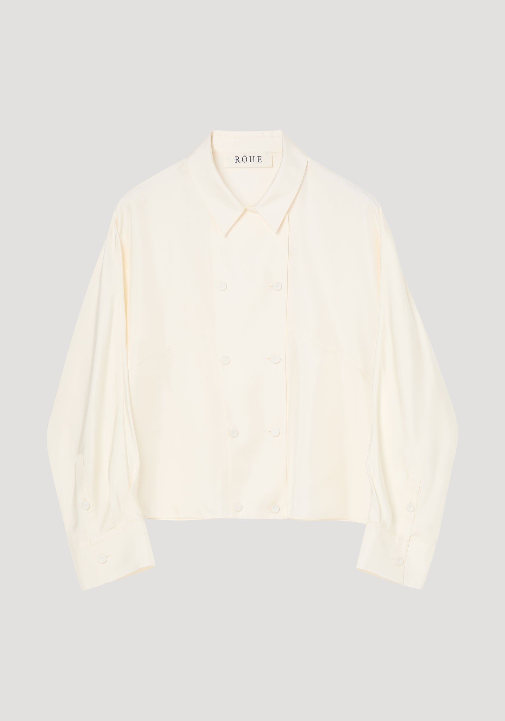 Double breasted silk top | cream with a pointed collar, long sleeves, button front and softly gathered cuffs on a neutral background
