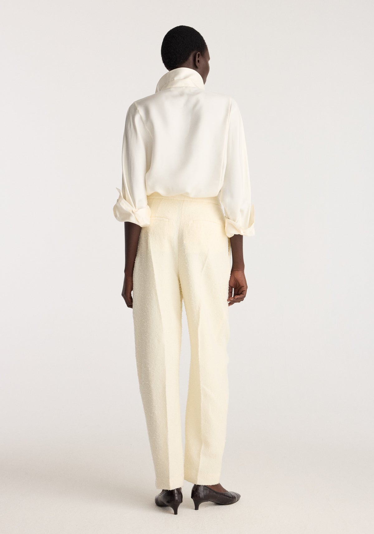Puck - Sculptural bouclé tailored trousers | cream shown from the back on a model wearing a white blouse and black shoes in a neutral studio