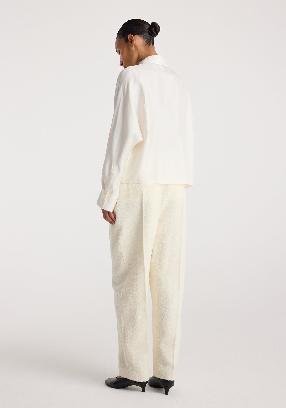 Double breasted silk top | cream shown from the back on a model, featuring a relaxed fit, long sleeves, and a clean cream finish.