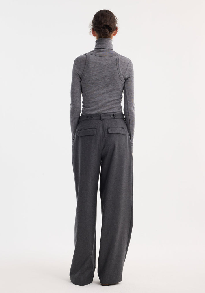 Double-layer wool top in mid grey melange worn by a model, showcasing a fitted turtleneck paired with high-waisted trousers, highlighting its tailored, monochromatic style.