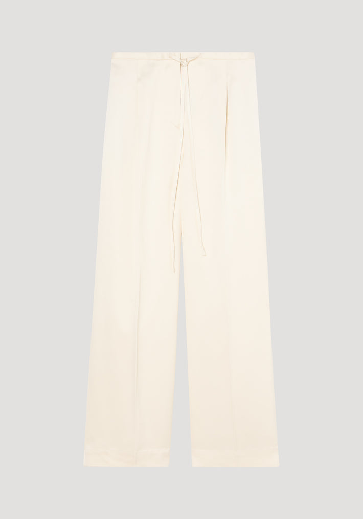 Relaxed drawstring satin trousers in cream, featuring wide-leg design, drawstring waistband, front pleats, and back welt pockets, made from 100% viscose satin.