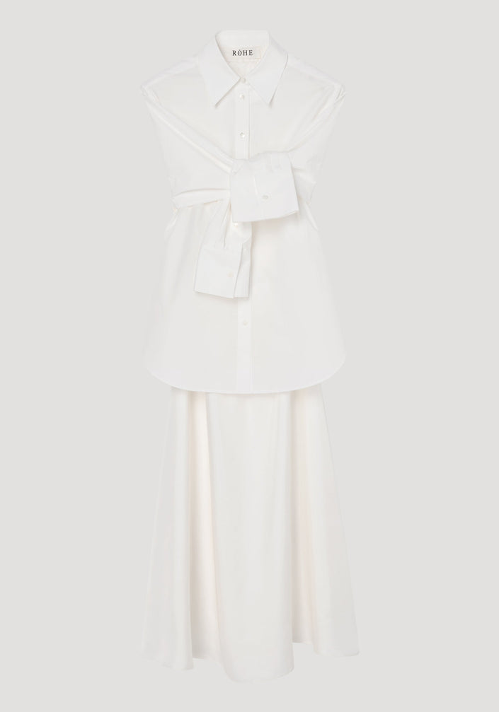 Poplin silk combined gilet-dress in optic white, featuring a deconstructed design with open armholes, buttoned wrap belt, and a fluid silk skirt.