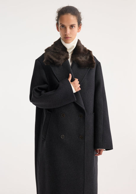 Double-breasted coat with faux fur collar: model wears a charcoal-gray wool coat with a brown collar, black buttons, white turtleneck, and black trousers.