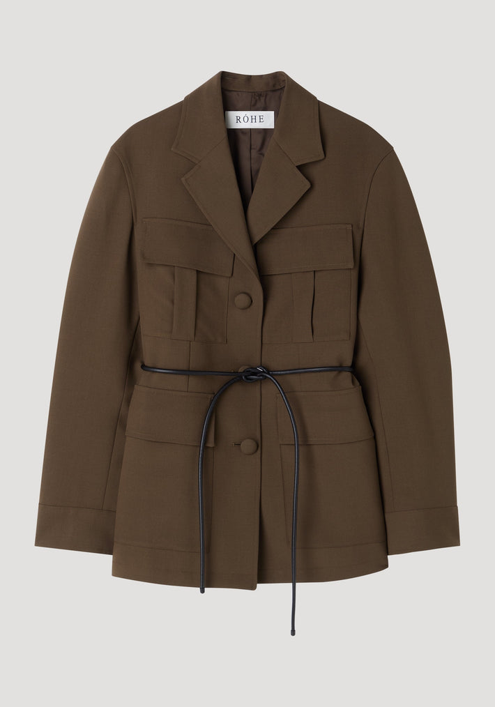 Safari blazer-jacket in deep olive-brown with notched lapel, four flap pockets, black tie-belt, and covered buttons; crafted from 100% virgin wool for a relaxed fit.