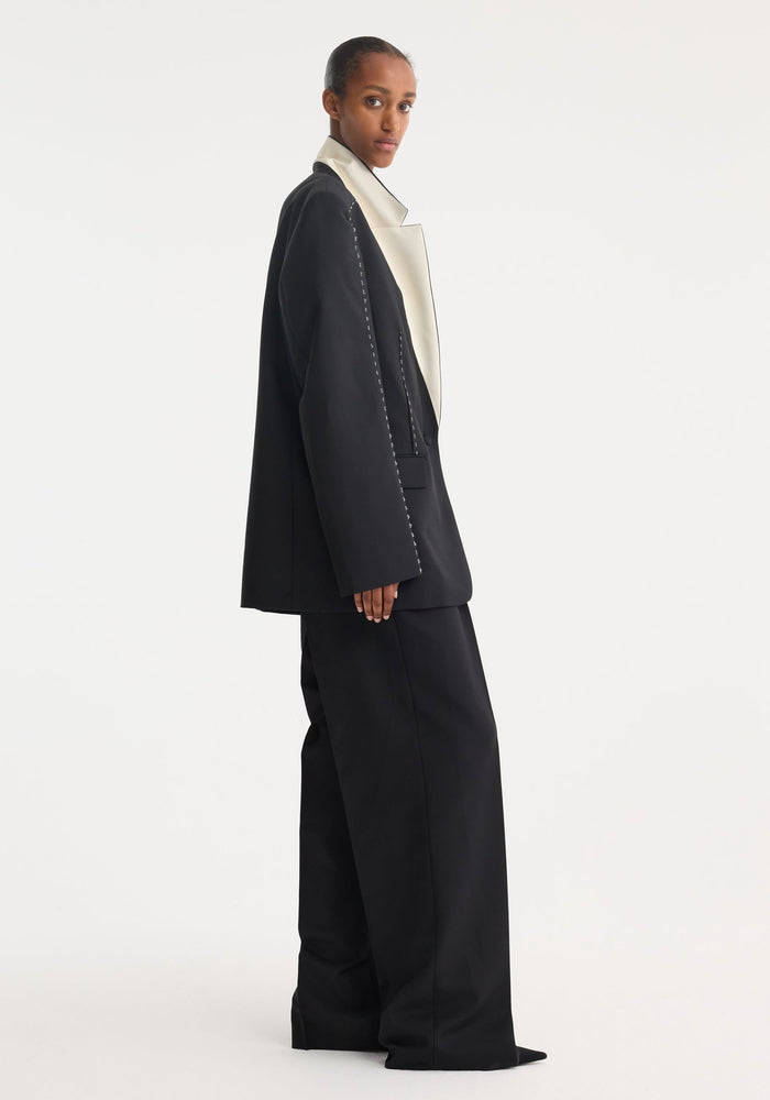 Contrast detail blazer | black on model, showcasing its oversized fit, white lapel, and wide-leg trousers. Made from a lightweight virgin wool-mohair blend.